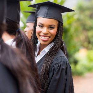 Pretty university graduate looking back at graduation ceremony